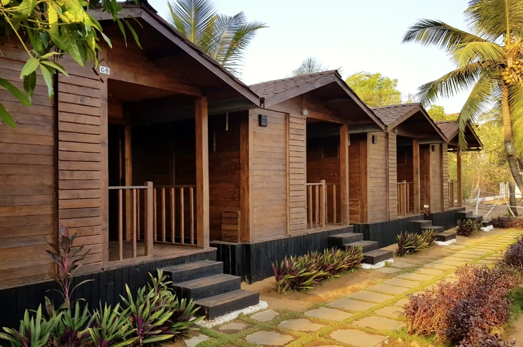 Row of wooden resort cottages along a stone path